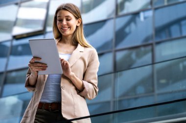 Şehir planında dijital tablet kullanan başarılı genç kadının portresi. İş adamları konsepti