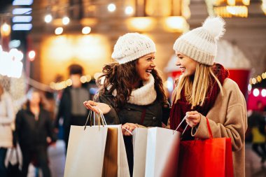 Mutlu kadın arkadaşlar Noel 'de hediye alışverişi yapıyorlar. İnsanlar tatil alışverişi kavramını benimsiyor.