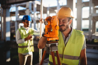 İnşaat alanında Theodolite ile çalışan mühendis müfettişi. İnsanlar endüstriyel kavramı geliştiriyor