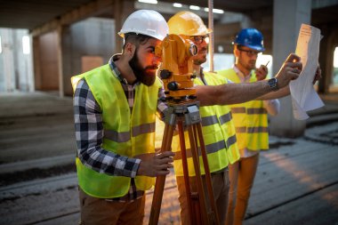 İnşaat alanında Theodolite ile çalışan mühendis müfettişi. İnsanlar endüstriyel kavramı geliştiriyor