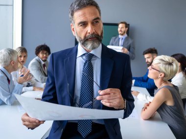 Çeşitli mutlu iş adamları toplantı odasında, ofiste çalışıyorlar..