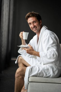 Bornozlu genç adam otelde kahve içiyor, spa merkezinde..