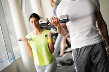 Spor salonunda birlikte antrenman yapan bir grup mutlu insan.