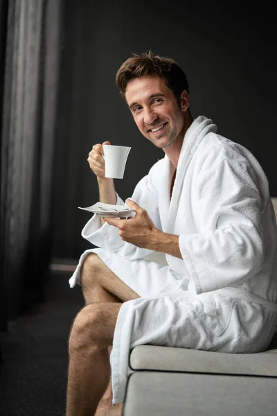 若い男でバスローブを着たコーヒーを飲んでホテル スパセンター — ストック写真