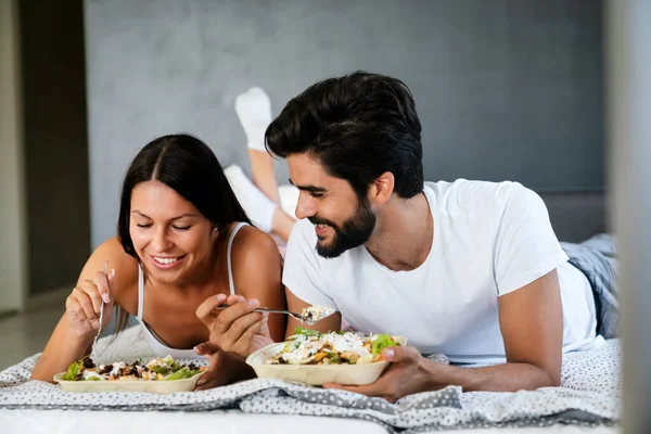 Romantik mutlu çift yatakta kahvaltı yapıyor. Aşk, insanlar, yemek konsepti