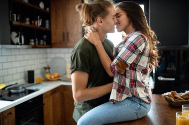Güzel seksi çift evde oynaşırken sarılıp öpüşüyorlar.