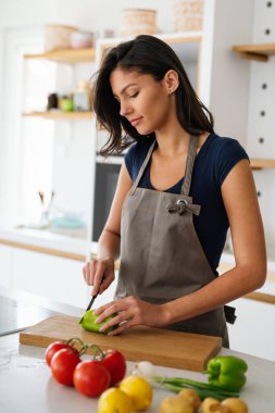 Mutfakta salata yapan güzel bir kadın gülümseyen, gülen ve neşeli.