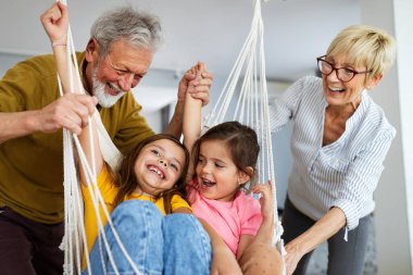 Torunlar eğleniyor, dedelerle evde oynuyorlar. Aile sevgi üretimi konsepti