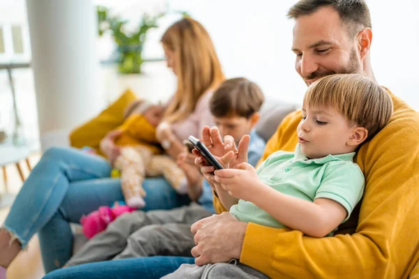 Mutlu genç aile eğleniyor ve evde birlikte oynuyorlar. Ebeveynlik, çocukluk, mutluluk kavramı