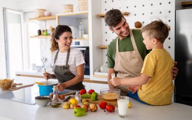 Mutfakta mutlu bir aile birlikte yemek pişiriyor. Evde sağlıklı yiyecekler..