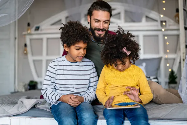 快乐的父亲和孩子们使用数字平板电脑 在家里玩的开心 多族裔家庭幸福概念 — 图库照片