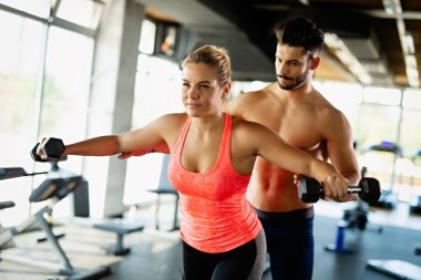 Formda bir kadına spor salonunda yardımcı olan kişisel antrenör. Spor insanları sağlıklı yaşam tarzı konsepti