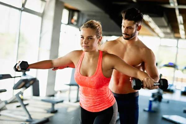 私人教练帮助一个健康的女人在健身房锻炼 体育人士健康生活方式概念 — 图库照片