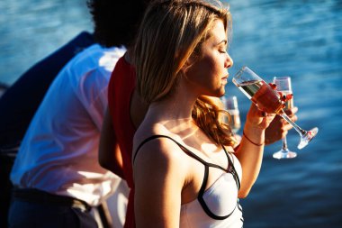 Bir grup arkadaş içiyorlar, dans ediyorlar ve dışarıda eğleniyorlar.