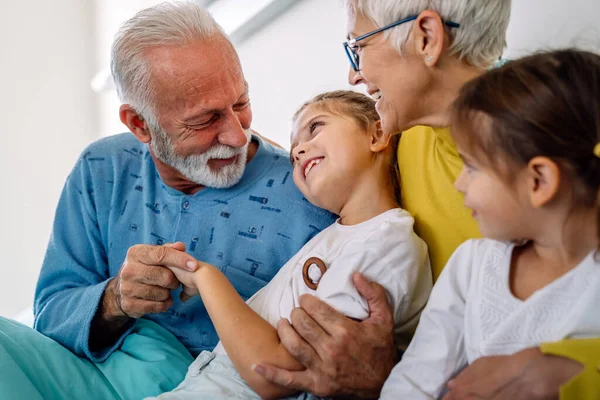 病院のベッドで高齢男性の患者を訪れる幸せな家族 家族の概念 — ストック写真