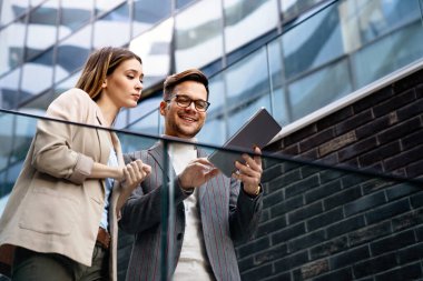 Dijital tablet kullanarak sosyal medya stratejisi üzerinde çalışan iki yaratıcı iş adamı. İş adamları konsept çalışır