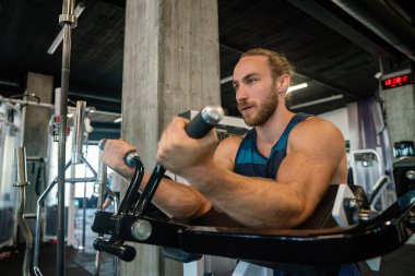 Yakışıklı, kaslı, fit adam spor salonunda sıkı çalışıyor.