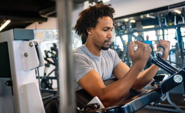 Spor salonunda çalışan sağlıklı genç bir adam.
