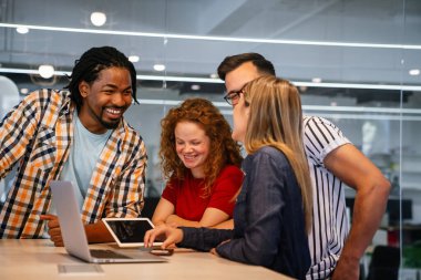 Mutlu yaratıcı tasarımcılar, iş adamları beyin fırtınası yapıyor ve iş yerinde çalışıyor.
