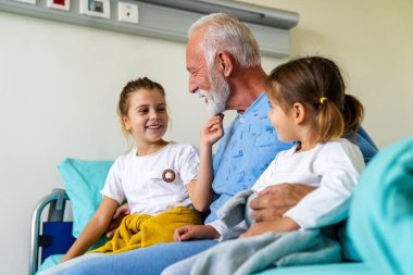 Coronavirüs tedavisi gören büyükbabayı hastanede ziyaret eden küçük kızlar. Sağlık, virüs, aile destek konsepti
