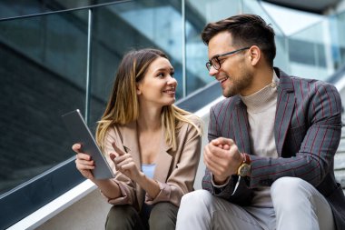 İş adamları, şehir planındaki işyerinde eğleniyor, çalışıyor ve sohbet ediyorlar.