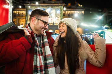 Mutlu çift dışarıda Noel alışverişinde birlikte eğleniyor. Tatil insanlara mutluluk sunar
