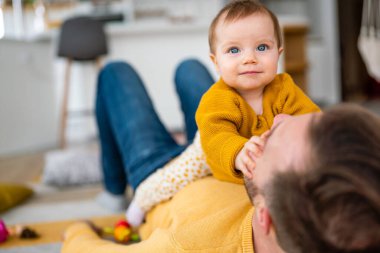 Baba ve kızı gülüyor ve kaynaşıyorlar. Babası ve küçük kızı evde vakit geçiriyorlar. Bekar baba eğlence aile hayatı kavramını sever.