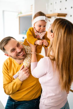 Mutlu aile, anne, baba ve kız dinleniyor ve evde eğleniyorlar.