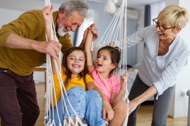 Torunlar eğleniyor, dedelerle evde oynuyorlar. Aile sevgi üretimi konsepti