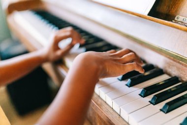 Müzik eğitimi. Mutlu siyah kız evde piyano çalıyor.
