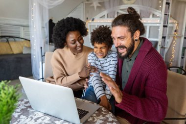 Genç, çoklu etnik kökenli neşeli aile, akrabalarıyla görüntülü sohbet yoluyla konuşuyor. Halk teknolojisi çevrimiçi iletişim kavramı