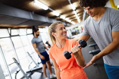 Spor salonunda antrenörle çalışan güzel bir kız.