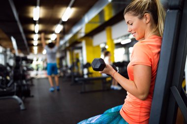 Güzel bir kadın spor salonunda çalışıyor. 