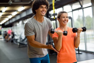 Spor salonunda antrenörle çalışan güzel bir kız.