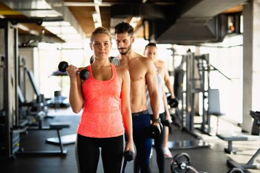 Spor salonunda egzersiz yapan bir grup mutlu zinde genç insan. Spor helatı yaşam tarzı konsepti