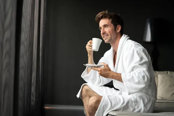 若いです幸せなハンサムな男飲む朝コーヒーでバスローブ — ストック写真