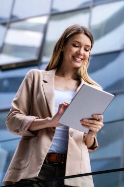 Şehir planında dijital tablet kullanan başarılı genç kadının portresi. İş adamları konsepti
