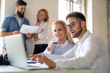 Birlikte çalışan ve ofiste gülümseyen yaratıcı iş adamlarının portresi. Başlangıçta çok ırklı iş adamları.