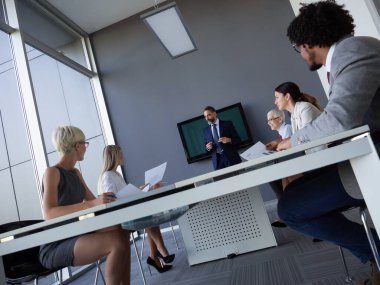 Çeşitli mutlu iş adamları toplantı odasında, ofiste çalışıyorlar..