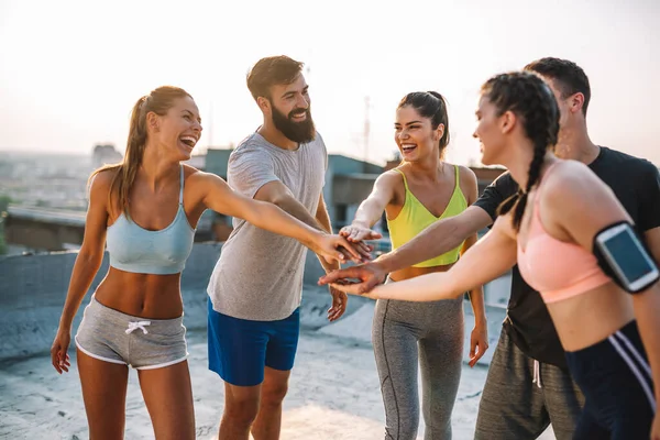 Bir grup mutlu zinde insan çatıda birlikte egzersiz yapıyor. Spor, sağlıklı yaşam konsepti