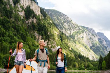 Sırt çantalı bir grup arkadaş dağda yürüyüş yapıyor. Trekker, spor, yürüyüş ve seyahat konsepti