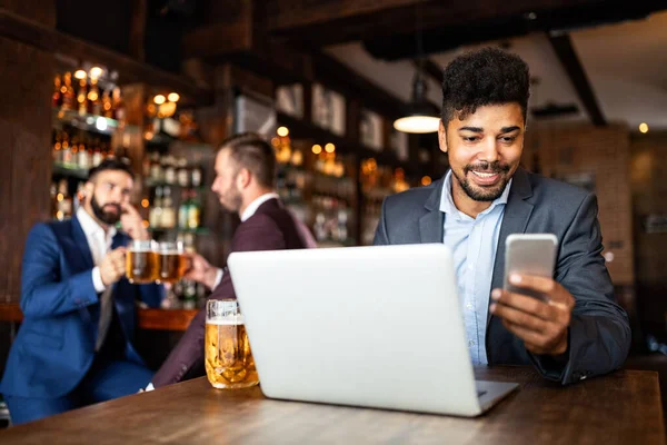 İş arkadaşları barda sosyalleşiyor ve birlikte bira içiyor.