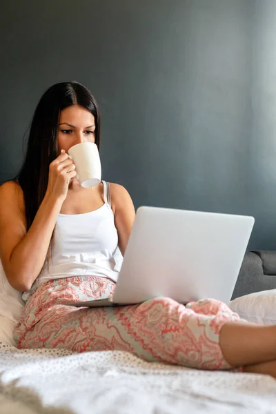 幸せな若い女性が働いて 自宅でノートパソコンでウェブサーフィン 家庭の概念 — ストック写真