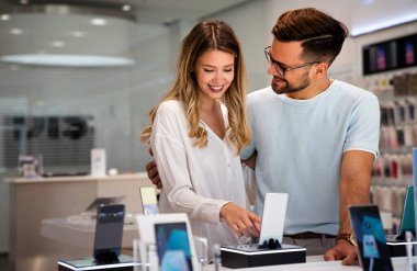 Teknoloji alışverişi dijital cihaz konsepti. Mobil dükkanından yeni bir akıllı telefon alan mutlu gençler.