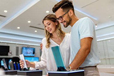 Yeni bir dijital cihaz alıyorum. Mutlu çift mağazadan bir cep telefonu alıyor..