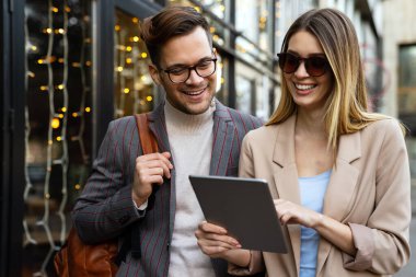 İki başarılı gülümseyen iş adamının portresi. Kentsel arka planda birlikte yürüyüp konuşuyorlar.