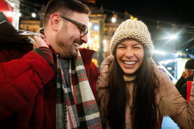 Şehirde Noel için alışveriş yapan mutlu bir çiftin portresi. İnsanlar tatil mutluluk satışı konsepti