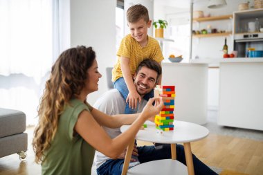 Mutlu aile kavramı. Güzel, genç ebeveynler evlerinde oğluyla oynuyorlar..