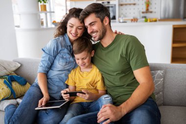 Mutlu aile evde teknoloji aletlerini birlikte kullanıyor. Halk, eğitim kavramı.
