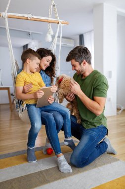 Mutlu genç aile eğleniyor, evde birlikte oynuyorlar. Mutlu çocukluk kavramı